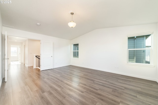 spare room with vaulted ceiling and hardwood / wood-style floors