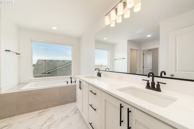 bathroom with a relaxing tiled tub and vanity