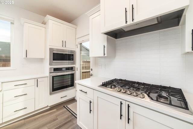 kitchen featuring tasteful backsplash, appliances with stainless steel finishes, white cabinets, and light hardwood / wood-style floors