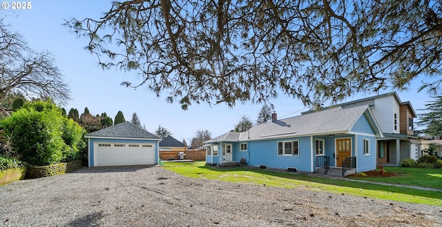 view of front of home featuring a garage, a front yard, fence, and an outbuilding