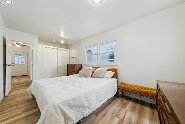 bedroom with light wood finished floors and a closet