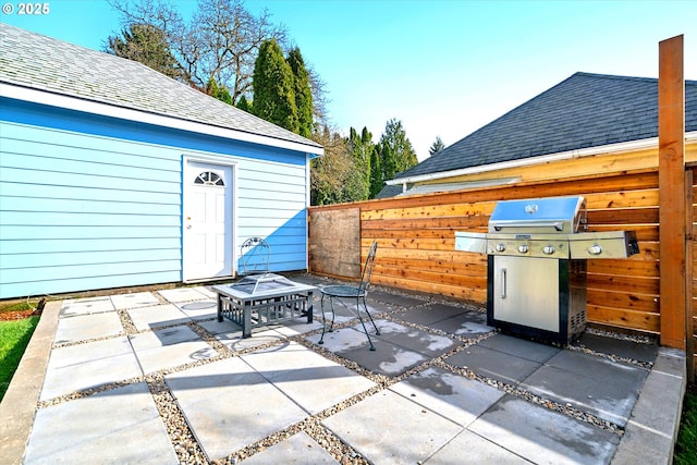 view of patio featuring fence and a grill