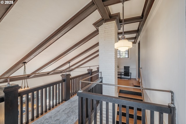 hall featuring an upstairs landing, vaulted ceiling with beams, and ornate columns