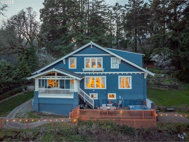 back of property with a deck and fence