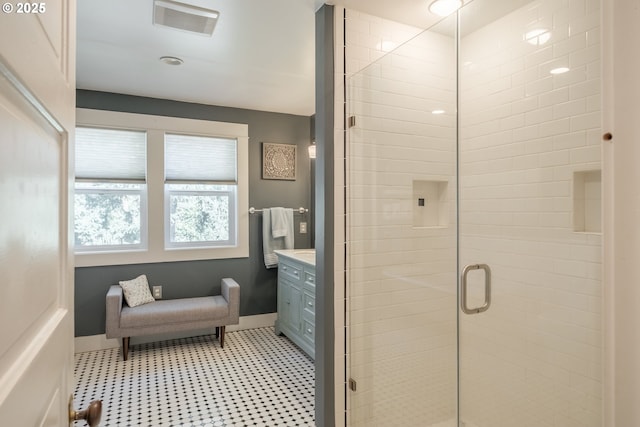 bathroom featuring a stall shower, vanity, and baseboards