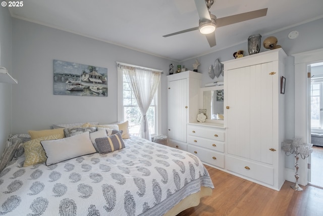 bedroom with multiple windows, light wood-type flooring, and crown molding