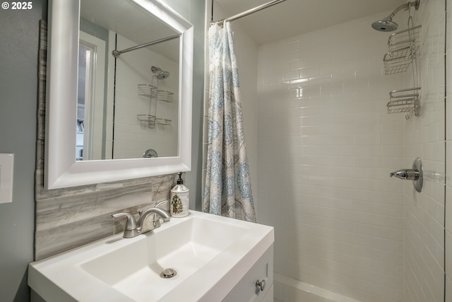 bathroom featuring tiled shower, backsplash, and vanity