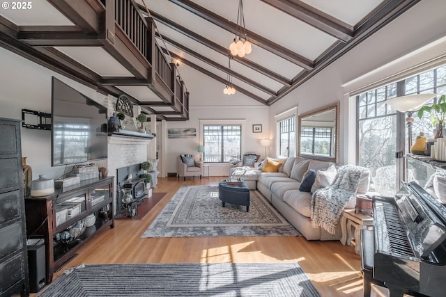 living room featuring a fireplace, high vaulted ceiling, beamed ceiling, and wood finished floors