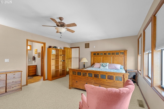 bedroom with a ceiling fan, baseboards, ensuite bath, carpet flooring, and visible vents