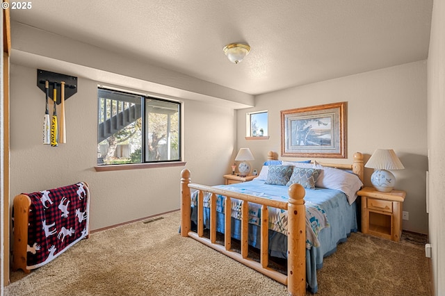 bedroom featuring baseboards, visible vents, carpet, and a textured ceiling