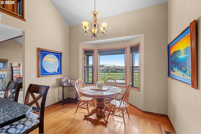 dining space with wood finished floors, baseboards, and a notable chandelier