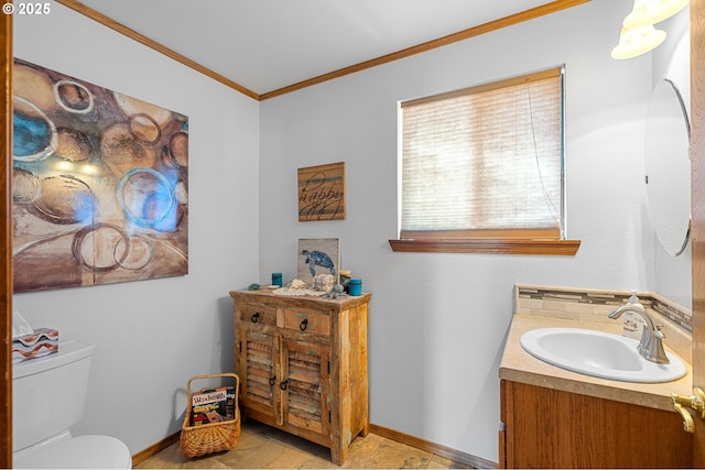 half bathroom with baseboards, toilet, vanity, and crown molding
