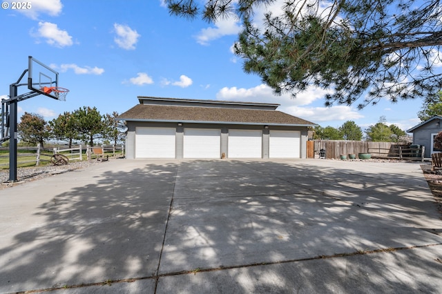 view of home's exterior featuring a garage, a shingled roof, and fence