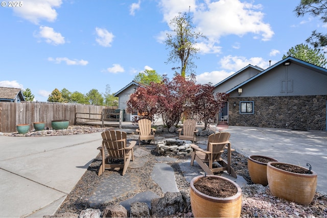 view of patio featuring an outdoor fire pit and fence