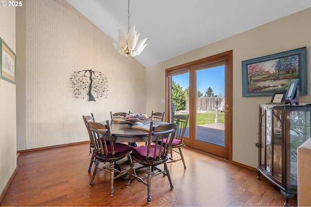 dining space featuring wood finished floors, baseboards, and an inviting chandelier