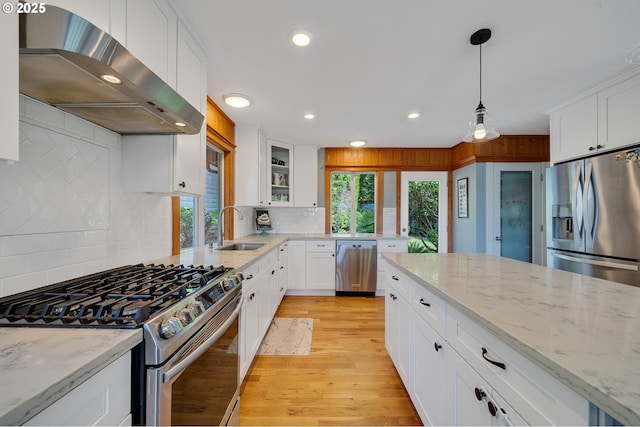 1626 NE Regatta Way, Lincoln City, OR 97367 - kitchen with under cabinet range hood, appliances with stainless steel finishes, a sink, light wood-type flooring, and white cabinetry