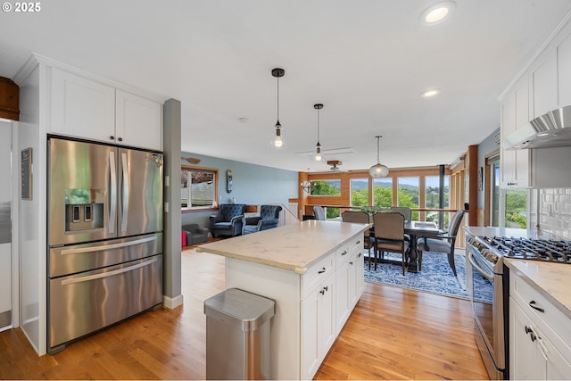 1626 NE Regatta Way, Lincoln City, OR 97367 - kitchen with stainless steel appliances, light wood-type flooring, white cabinets, open floor plan, and recessed lighting