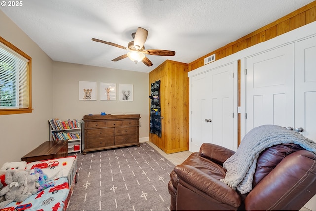 1626 NE Regatta Way, Lincoln City, OR 97367 - living area with a ceiling fan, wooden walls, carpet floors, and a textured ceiling