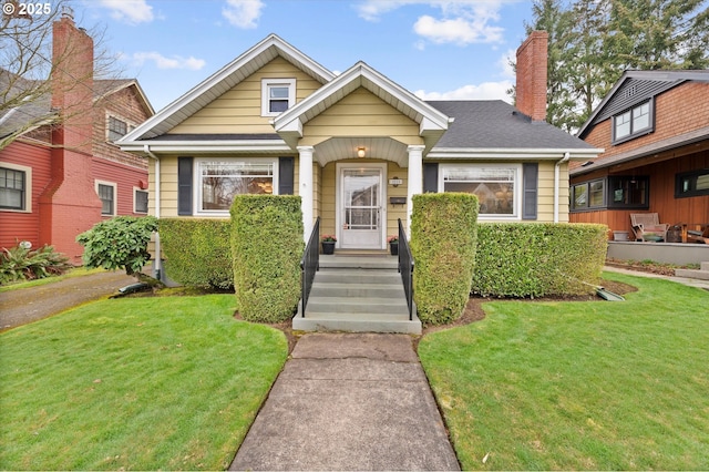 bungalow-style house featuring a front lawn