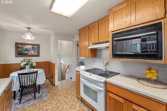 kitchen featuring under cabinet range hood, light countertops, black microwave, and white range with electric stovetop