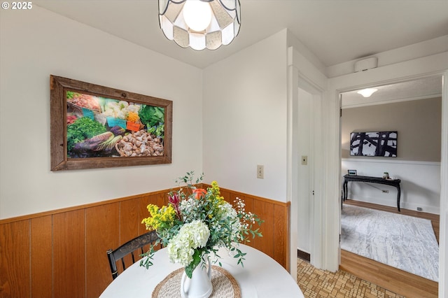 dining area with wooden walls and wainscoting