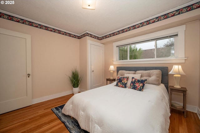 bedroom with wood finished floors and baseboards