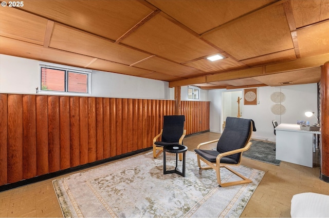 sitting room featuring a wainscoted wall and wooden walls