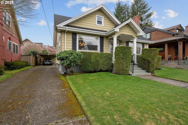 view of front of property with aphalt driveway, fence, and a front yard