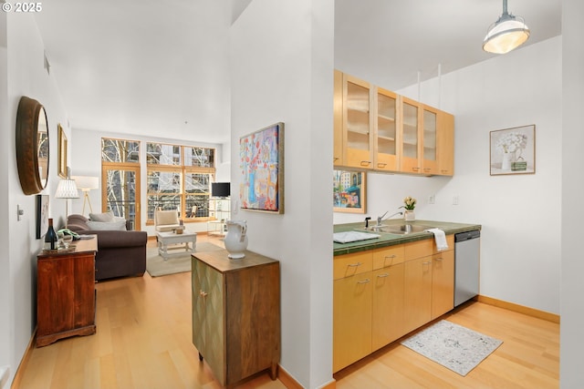 kitchen featuring sink, dishwasher, light hardwood / wood-style flooring, and light brown cabinets