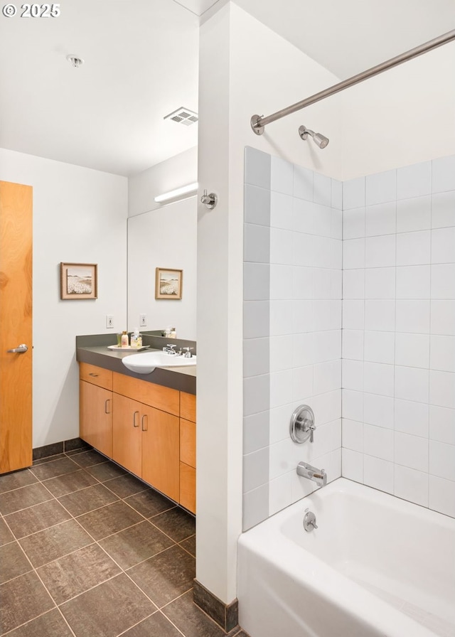 bathroom featuring tiled shower / bath and vanity