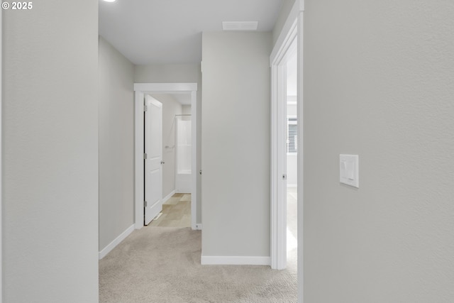 corridor featuring light colored carpet