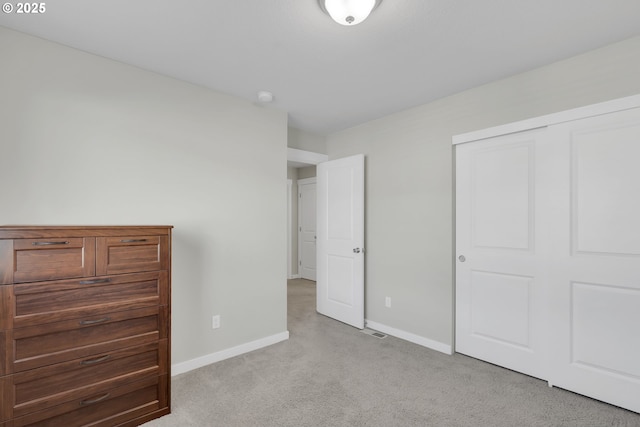 unfurnished bedroom with light colored carpet and a closet