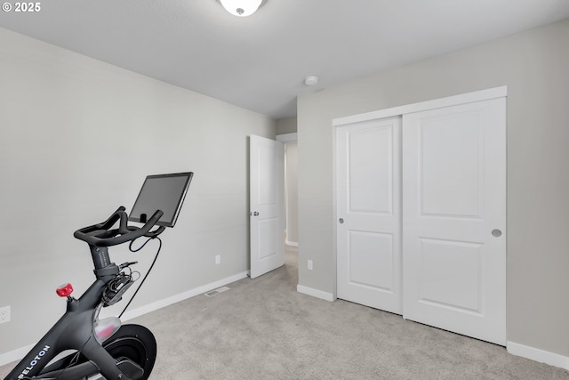 exercise room featuring light colored carpet