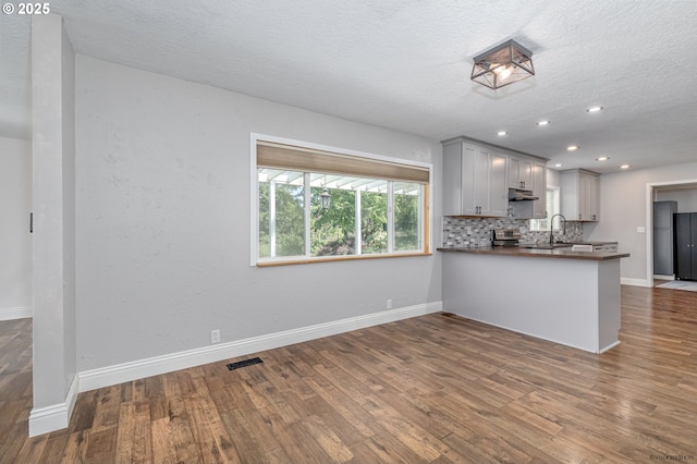 35538 SE Snuffin Rd, Estacada, OR 97023 - kitchen featuring gray cabinetry, a textured ceiling, dark wood-style floors, dark countertops, and a peninsula