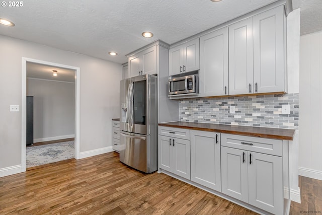 35538 SE Snuffin Rd, Estacada, OR 97023 - kitchen featuring stainless steel appliances, butcher block countertops, wood finished floors, baseboards, and decorative backsplash