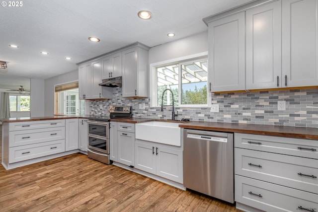 35538 SE Snuffin Rd, Estacada, OR 97023 - kitchen with stainless steel appliances, a sink, wood counters, under cabinet range hood, and recessed lighting