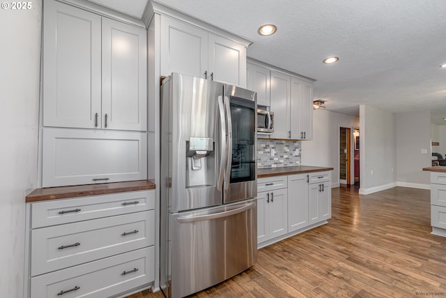 35538 SE Snuffin Rd, Estacada, OR 97023 - kitchen with stainless steel appliances, wood counters, tasteful backsplash, baseboards, and light wood-style floors
