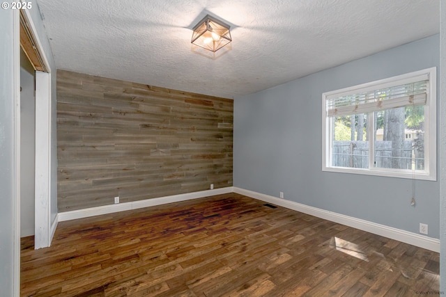 35538 SE Snuffin Rd, Estacada, OR 97023 - empty room featuring wood walls, wood finished floors, baseboards, and a textured ceiling