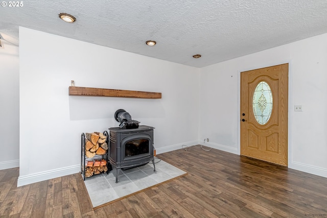 35538 SE Snuffin Rd, Estacada, OR 97023 - entryway featuring a wood stove, wood finished floors, baseboards, and a textured ceiling