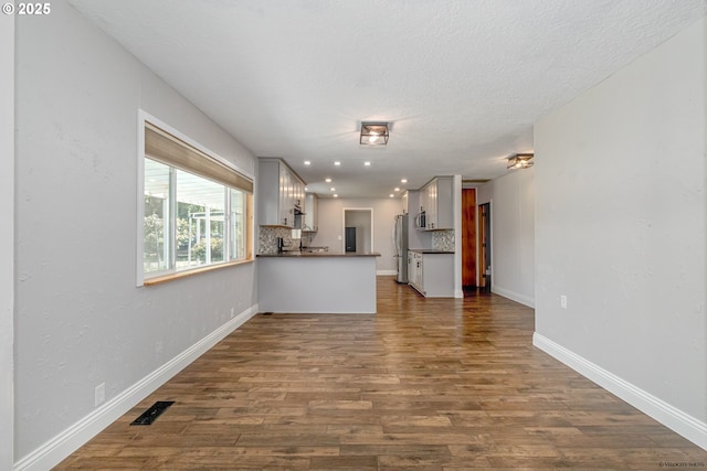 35538 SE Snuffin Rd, Estacada, OR 97023 - unfurnished living room featuring dark wood finished floors, baseboards, recessed lighting, and a textured ceiling