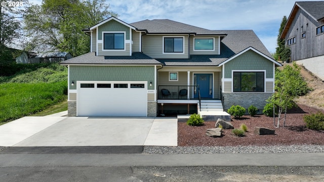35681 Bella Ridge Loop, Astoria, OR 97103 - craftsman-style house featuring stone siding, a garage, covered porch, and driveway