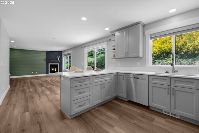 35681 Bella Ridge Loop, Astoria, OR 97103 - kitchen with stainless steel dishwasher, gray cabinets, a sink, a large fireplace, and open shelves
