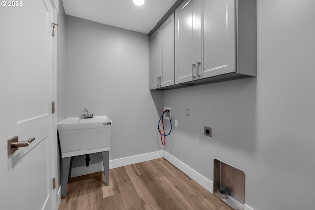 35681 Bella Ridge Loop, Astoria, OR 97103 - laundry area featuring cabinet space, wood finished floors, hookup for a washing machine, baseboards, and hookup for an electric dryer
