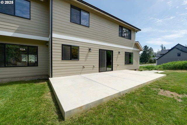 35681 Bella Ridge Loop, Astoria, OR 97103 - rear view of house with a patio and a lawn