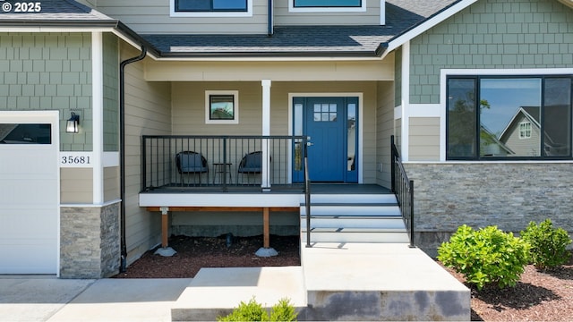 35681 Bella Ridge Loop, Astoria, OR 97103 - property entrance with covered porch, a shingled roof, and stone siding