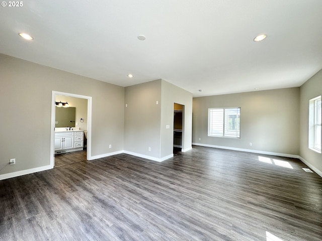 spare room featuring recessed lighting, dark wood-type flooring, and baseboards