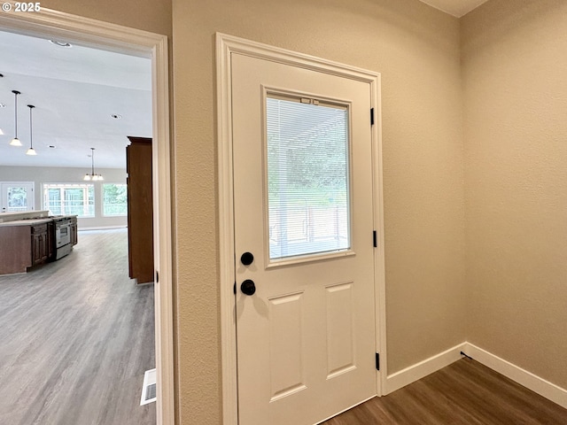 doorway featuring visible vents, baseboards, and dark wood-style flooring