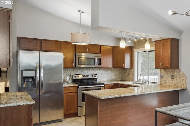 kitchen featuring stainless steel appliances, vaulted ceiling, decorative light fixtures, and kitchen peninsula