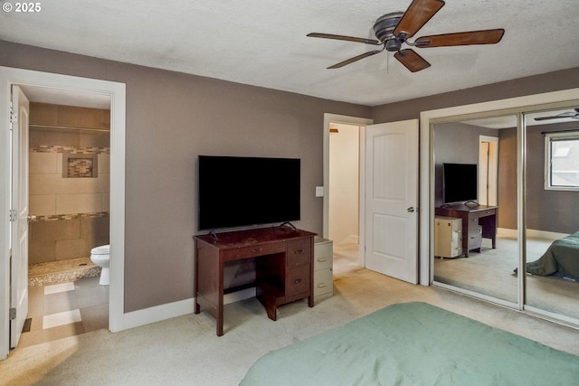 carpeted bedroom with a closet, ceiling fan, and ensuite bathroom