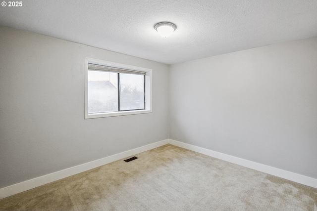 carpeted spare room featuring a textured ceiling